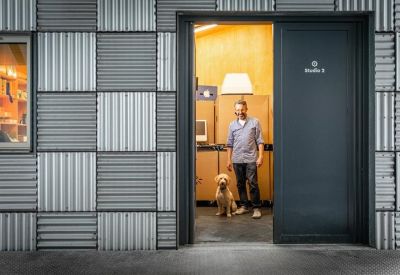 Entrance to a private studio unit with a grey door and textured metal siding.