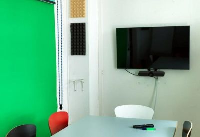 Creative meeting space featuring a green screen backdrop and acoustic wall panels.