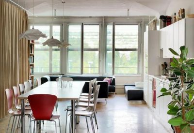 Sunlit communal area featuring a long table and views of the surrounding neighborhood.