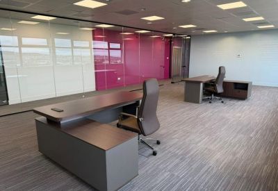 Spacious private office at Hermiston Quay, 5, Cultins Road with modern desks and a vibrant pink feature wall.