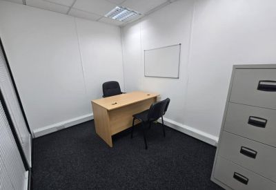 Private internal office suite with a wooden desk, two chairs, and a whiteboard.