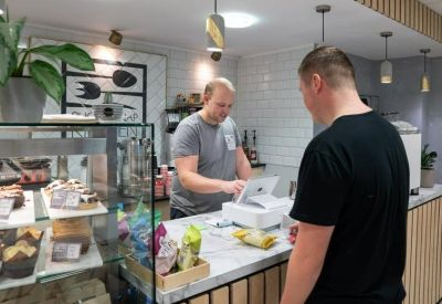 On-site café area with a barista at the counter and fresh pastries on display.