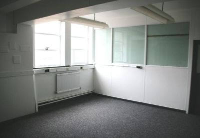 Private office suite with white walls, grey carpet, and large windows.