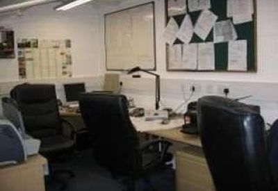 Office workspace with black leather chairs and notice boards.