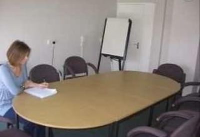 Meeting room with a large oval table and a flip chart.