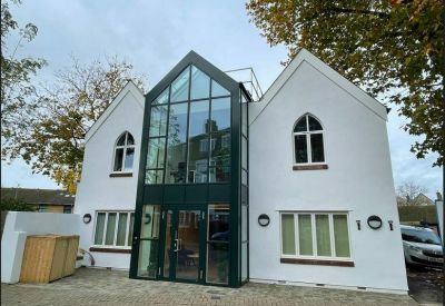 Exterior view of the white facade and central glass atrium of Hyde Park House, 5 Manfred Road.