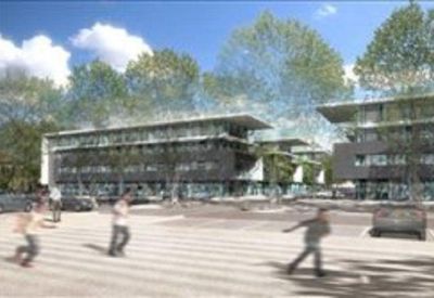 Outdoor plaza area with greenery and pedestrians in front of contemporary office blocks.