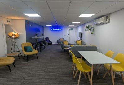 Lounge area with yellow armchairs and a dining table.