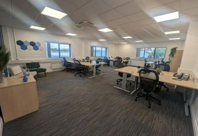Spacious open-plan office with multiple workstations and natural light.