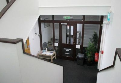 Entrance lobby with a dark wood door frame and a small reception desk.
