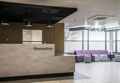 Reception area featuring a stone desk and a lounge with a purple sofa.