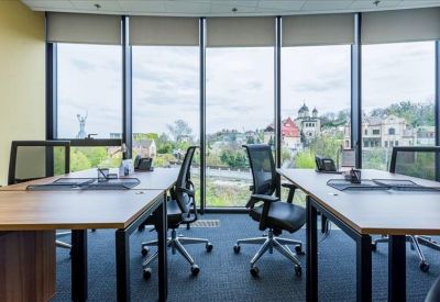 Clean communal kitchen and break area with white cabinetry and wooden floors.