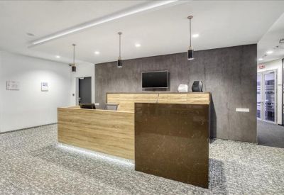 Contemporary reception area with a wooden front desk and dark stone feature wall.