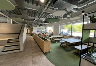 Spacious dining area with picnic-style wooden tables and bright green flooring.