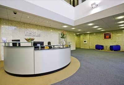 Professional reception desk with a curved white counter and blue accent chairs.