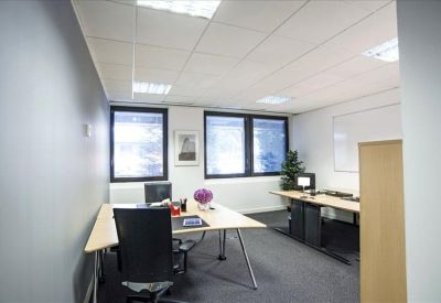 Private office suite with three desks and large windows for natural light.