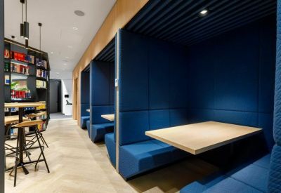 Private blue acoustic meeting booths with built-in wooden tables.