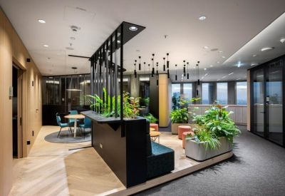 Open-plan coworking area with a wooden central table and decorative pendant lighting.
