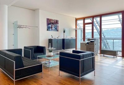 Contemporary lounge area with black leather sofas and a glass-topped coffee table.