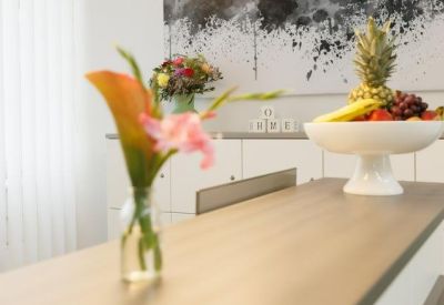 Communal break area featuring a bowl of fresh fruit and a floral arrangement on a wooden counter.