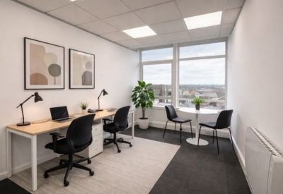 Small private office with two desks and large windows.