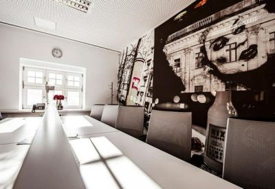 Modern conference room with long tables and artistic black and white wall mural.