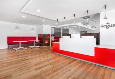 Modern reception area with a sleek white and red desk and wood-style flooring.