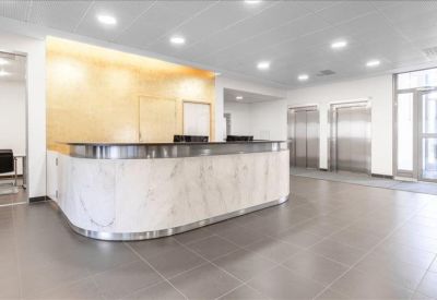 Marble-style curved reception desk in a brightly lit lobby.