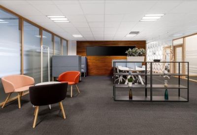 Modern lounge area with colourful armchairs and a minimalist black display shelf.