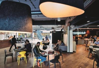 Spacious communal lounge with a large feature lampshade and colourful seating.