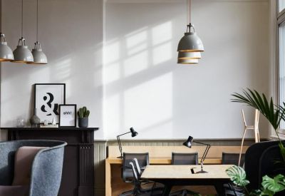 Modern open-plan office with individual workstations and industrial pendant lights.