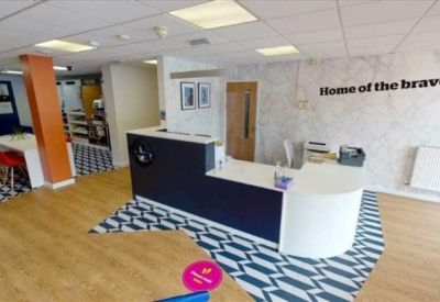 Modern reception area with a blue and white patterned floor and Home of the Brave wall text.