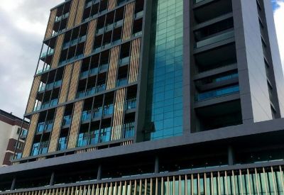 Exterior view of the modern multi-story glass and timber building at Konak Mahallesi, Lefkoşe Cd, Bursa.