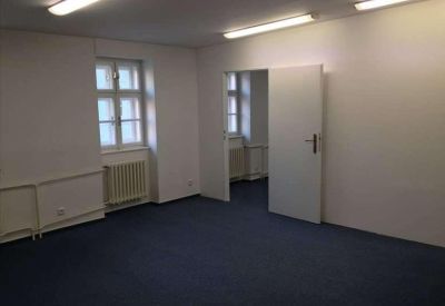 Bright, empty private office suite with blue carpeting and white walls.