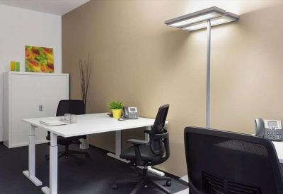 Modern private office with white height-adjustable desk and ergonomic chairs.