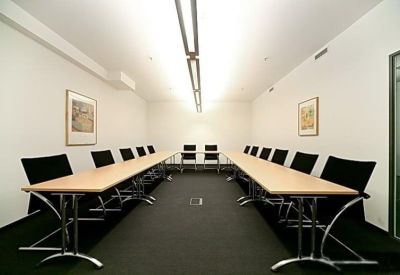 Large conference room with U-shaped table arrangement and bright overhead lighting.