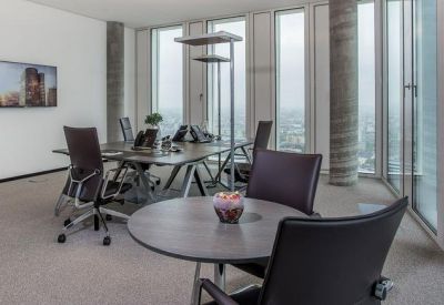 Spacious communal lounge area with a meeting table and a smaller round table for informal collaboration.