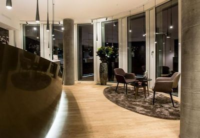 Elegant reception area with a curved desk and low-hanging pendant lights over a seating area.