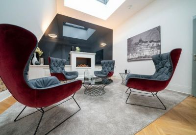 Lounge area with velvet wingback chairs and a modern fireplace.