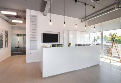 Minimalist white reception desk with modern pendant lighting.