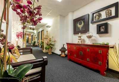 Lobby area featuring a bright red sideboard and ornate Asian-inspired wall art.