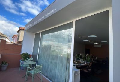 Private outdoor terrace with green metal furniture and views of traditional architecture.