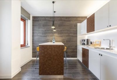 Communal kitchen area with a dark wood feature wall and breakfast bar.