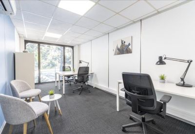 Private three-person office suite with light wood furniture and natural light.