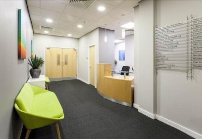 Modern reception area featuring a wooden desk and lime green accent chair.