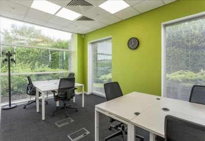 Bright private office suite with lime green feature wall and large windows.