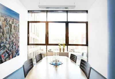 Sun-drenched meeting room with a long wooden table and a large city skyline mural.