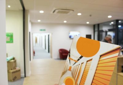 Bright hallway leading to office suites with a colorful graphic in the foreground.