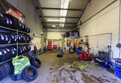 Industrial workshop space with tire storage racks and mechanical equipment.