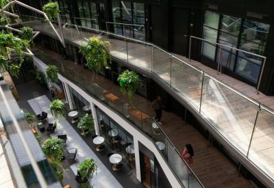 High-angle view of a multi-level atrium walkway decorated with lush green plants.